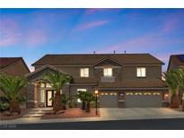 Charming two-story home featuring a tile roof, stone accents, and a well-manicured yard with palm trees at 3088 Via Flaminia Ct, Henderson, NV 89052