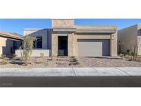 Beautiful single-story home with stone accents, neutral color palette, desert landscaping and brick paved driveway at 5030 Sandline Court, Las Vegas, NV 89135