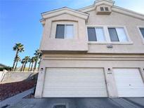 Two-story tan home featuring a two-car garage and desert landscaping at 6459 Rusticated Stone Ave # 103, Henderson, NV 89011