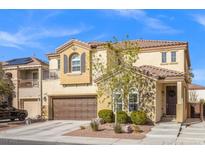 Inviting two-story home with a brown garage door, desert landscaping, and a charming entryway at 7078 Seabirds Pl, North Las Vegas, NV 89084