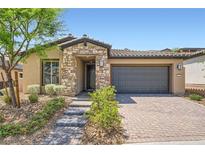 Charming single-story home featuring stone accents, low maintenance landscaping, and a brick paved driveway at 243 Sun Glaze Ave, Henderson, NV 89011