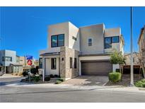 Modern two-story home with a two-car garage, stone accents, and beautiful landscaping against a bright blue sky at 513 Founders Creek Ave, North Las Vegas, NV 89084