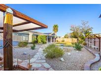 Expansive backyard featuring mature landscaping, a stone walkway and a covered patio, perfect for outdoor entertaining at 7913 Rushmore Ave, Las Vegas, NV 89131