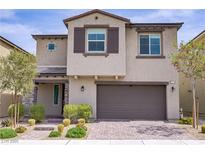 Charming two-story home with stucco facade, stone accents, a two-car garage, and professionally landscaped front yard at 8564 Scalpay St, Las Vegas, NV 89166