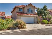 Charming two-story home featuring a red tile roof, front yard landscaping, and an attached two-car garage at 8771 Martinique Bay Ln, Las Vegas, NV 89147