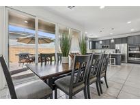 Open concept dining room featuring a dark wooden table and views of the backyard patio at 160 Lilt Ave, Henderson, NV 89011