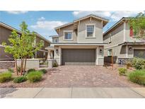 Two story home featuring a brick driveway, two car garage, and manicured landscaping at 160 Lilt Ave, Henderson, NV 89011