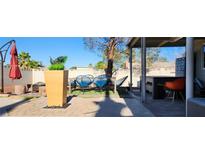 Landscaped backyard featuring an outdoor dining area, mature trees, and a patio at 5318 Palmyra Ave, Las Vegas, NV 89146