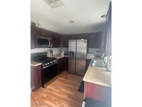 Well-lit kitchen featuring stainless steel appliances and cherry wood cabinets at 7098 Forest Vista St, Las Vegas, NV 89147