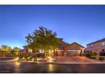 Beautiful home exterior featuring a well-manicured lawn, mature tree, and an inviting paver driveway leading to a two-car garage at 7311 Velvet Sky St, Las Vegas, NV 89131