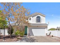 Charming two-story home with a well-manicured front yard, blue entry door and an attached two-car garage at 10313 Adams Chase St, Las Vegas, NV 89183