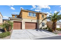 Stunning two-story home features a well-maintained yard, a dual-car garage, and a beautiful tan and brown exterior paint scheme at 1112 Adobe Creek Ct, North Las Vegas, NV 89084