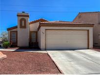 Charming single-story home featuring a two-car garage, desert landscaping, and a tiled roof at 1636 Royal Palm Dr, Las Vegas, NV 89128