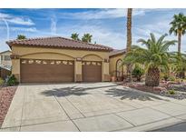 Charming single-story home with a two-car garage, desert landscaping, and a tiled roof at 372 Desert Cove Rd, Henderson, NV 89012