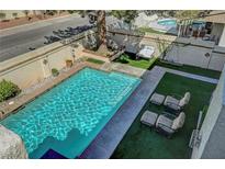 Relaxing backyard oasis with a sparkling pool, lounge area and privacy walls at 7420 Enchanted Hills Ct, Las Vegas, NV 89129