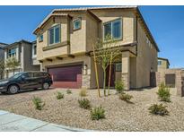 Two-story home featuring a red two-car garage and desert landscaping at 10748 Wild Poppy Ave, Las Vegas, NV 89129
