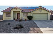 Charming single-story home with a red tile roof, solar panels, and low-maintenance desert landscaping at 4405 Testarossa Ln, North Las Vegas, NV 89081