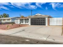 Charming single-story home with a large driveway and a modern black garage door at 5200 Longridge Ave, Las Vegas, NV 89146