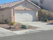 Exterior shot of a house with a two-car garage and desert landscaping in the front yard at 5404 Walcott Dr, Las Vegas, NV 89118