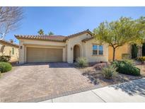 Charming single-story home featuring a brick driveway and well-manicured landscaping in a sunny neighborhood at 677 Viale Machiavelli Ln, Henderson, NV 89011