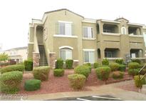 Well-maintained two-story building with stone accents, stairs, and lush shrubbery at 9303 Gilcrease Ave # 2164, Las Vegas, NV 89149