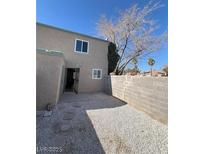 Enclosed backyard features a gravel-covered space, block wall, and access door at , Las Vegas, NV 89108