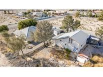 Wide aerial shot of a property with two houses, trees, and a large yard in a desert landscape at 4838 N Tioga Way, Las Vegas, NV 89149