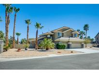 Inviting two-story home with desert landscaping, palm trees, and a three-car garage at 5640 Coe Estates Ct, Las Vegas, NV 89149