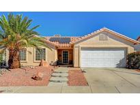 Charming single-story home featuring a well-maintained yard, tile roof, solar panels and an attached two-car garage at 702 Carlitos Ave, North Las Vegas, NV 89031