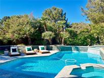 Backyard pool with lounge chairs and mature landscaping for privacy in a resort-style setting at 7988 Pinnacle Peak Ave, Las Vegas, NV 89113