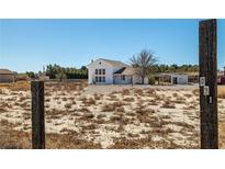 Charming two-story white home with a large yard and covered parking area at 861 Mcmurray Dr, Pahrump, NV 89060