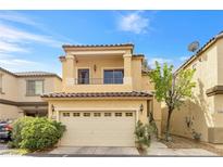 Charming two-story home with a tan facade, a balcony and a two-car garage and well-maintained landscaping at 9617 Sharp Horn Ct, Las Vegas, NV 89149