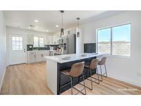 Bright kitchen features white cabinets, modern appliances, and an island with bar seating at 1945 Margarita Ave, Henderson, NV 89011