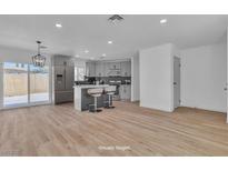 Open kitchen with gray cabinets, stainless appliances, and a kitchen island with bar seating at 2721 Bruce Cir, North Las Vegas, NV 89030
