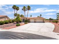 Charming single-story home with a spacious driveway and desert landscaping, complemented by tall palm trees at 5217 Cold River Ave, Las Vegas, NV 89130