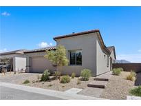 Stylish single-story home featuring desert landscaping, a two-car garage and a brick walkway under a clear blue sky at 10158 Super Jovian St, Las Vegas, NV 89143