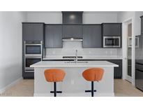 Modern kitchen features gray cabinetry, stainless steel appliances, and a center island with seating at 10158 Super Jovian St, Las Vegas, NV 89143
