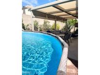 Above ground pool with pergola and backyard seating area at 2613 Country Mile Dr, Las Vegas, NV 89135