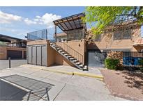 Exterior shot of a two-story condo featuring a stairway leading to an upper-level patio at 320 Shadybrook Ln # D, Las Vegas, NV 89107