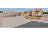 Beige single-story home featuring a spacious driveway, desert landscaping and a terracotta tile roof at 4322 Summers Shade St, Las Vegas, NV 89147