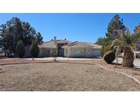 Spacious single-story home with a tile roof, circular driveway, and desert landscaping on a sunny day at 821 W Amarillo Ave, Pahrump, NV 89048