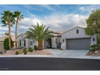 Charming single-story home boasts a well-manicured desert landscape, palm trees, and neutral color palette at 10261 Largo Sassetta Ct, Las Vegas, NV 89135