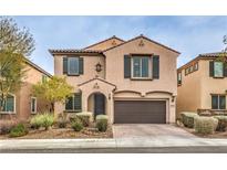 Two-story home boasts a desert-landscaped front yard, a two-car garage, and a charming stucco facade at 10960 Prairie Grove Rd, Las Vegas, NV 89179