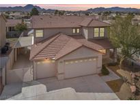 Two-story home featuring a three car garage, well-maintained landscaping, and a beautiful desert sunset backdrop at 1109 Pincay Dr, Henderson, NV 89015