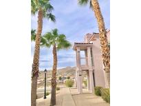 Building exterior with palm trees, sidewalks, and lovely mountain views on a sunny day at 1964 Las Palmas Ln # 244, Laughlin, NV 89029
