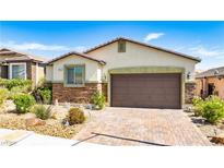 Charming single-story home with a well-manicured front yard and brick-paved driveway leading to a two-car garage at 2612 Tullamore Creek Ln, Laughlin, NV 89029