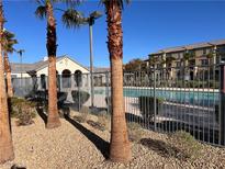 Community pool area with palm trees, pool house, and well maintained landscaping at 4561 Woolcomber St, Las Vegas, NV 89115