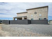 View of the home with a metal fence offering privacy and unique exterior design elements at 4830 E Comanche Dr, Pahrump, NV 89061