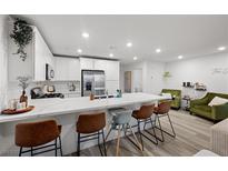 Modern kitchen featuring white cabinets, stainless steel appliances, and a large marble countertop island with seating at 6144 Rathbone St, Las Vegas, NV 89166