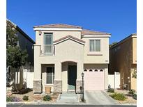 Charming two-story home featuring a stucco exterior, a small balcony, and a one-car garage at 1592 Evening Spirit Ave, Las Vegas, NV 89183